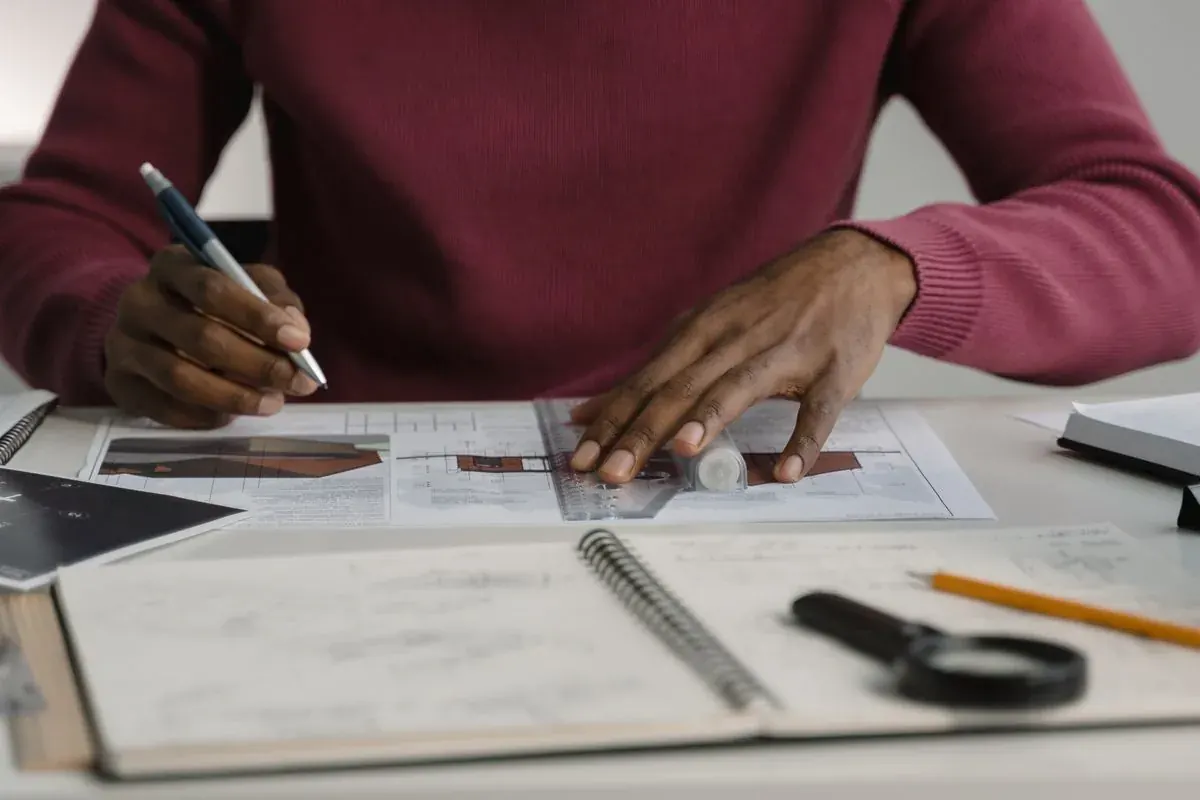 Architecte dessinant un plan de bâtiment sur sa table de travail
