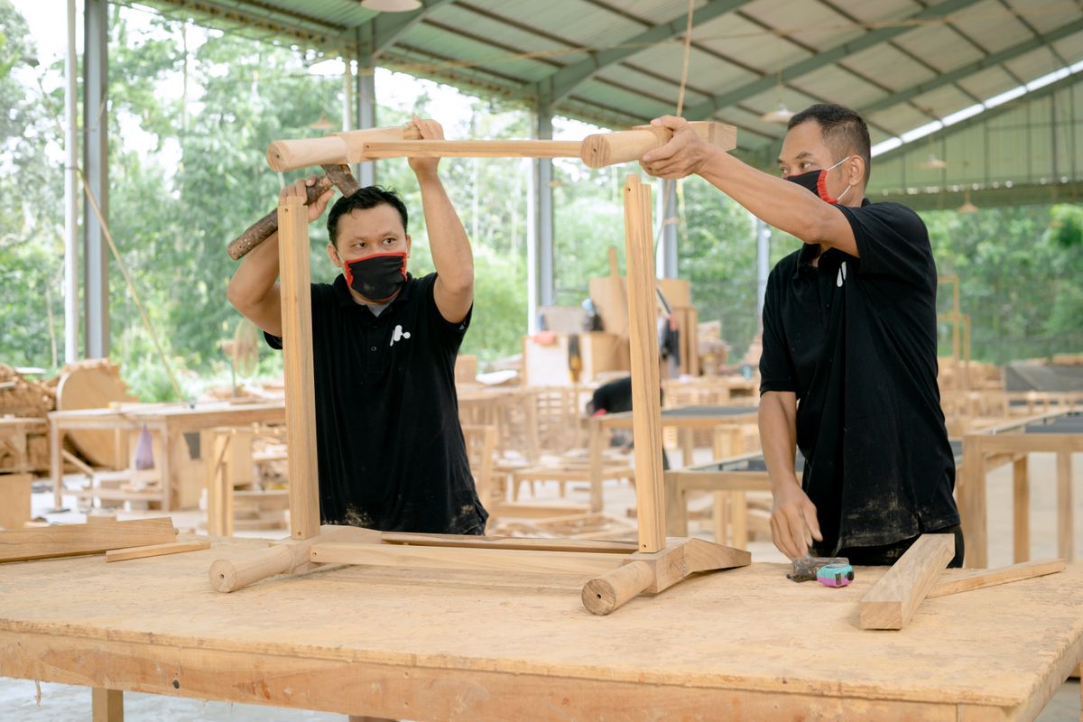 Charpentiers assemblant une structure en bois dans un atelier