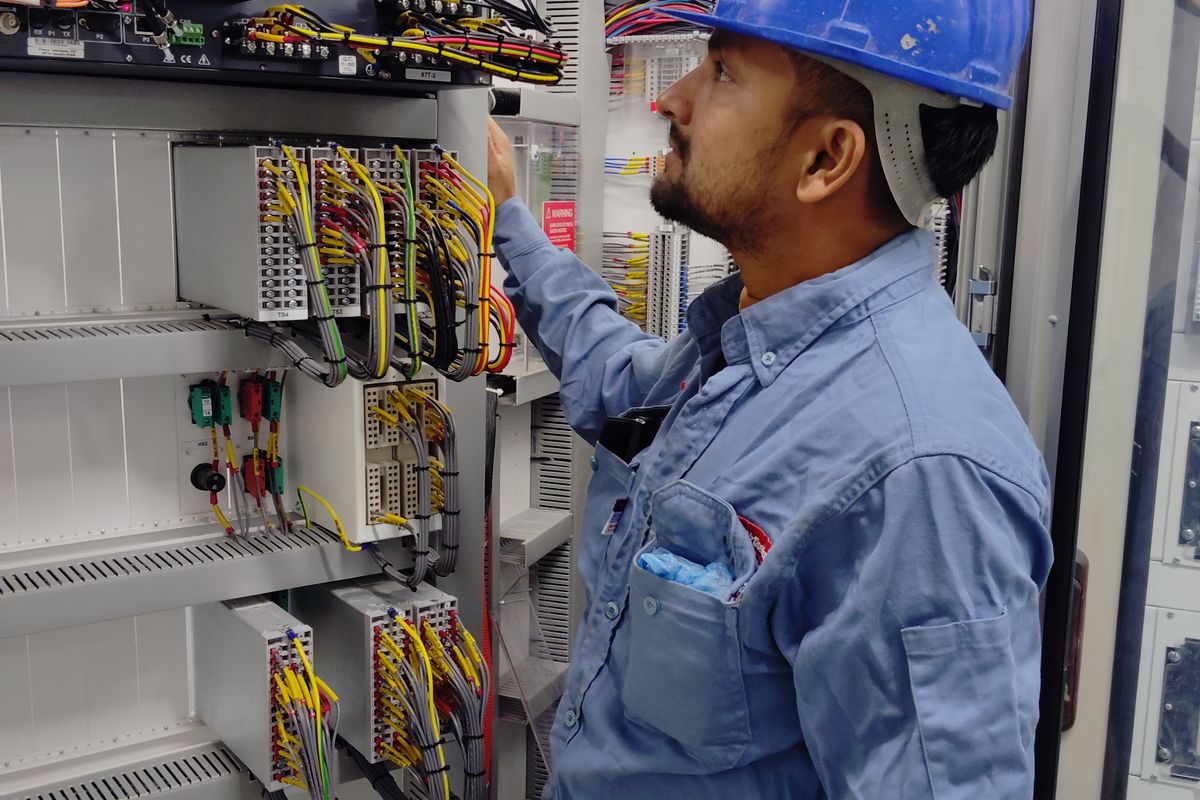 Électricien contrôlant le câblage d’une armoire électrique