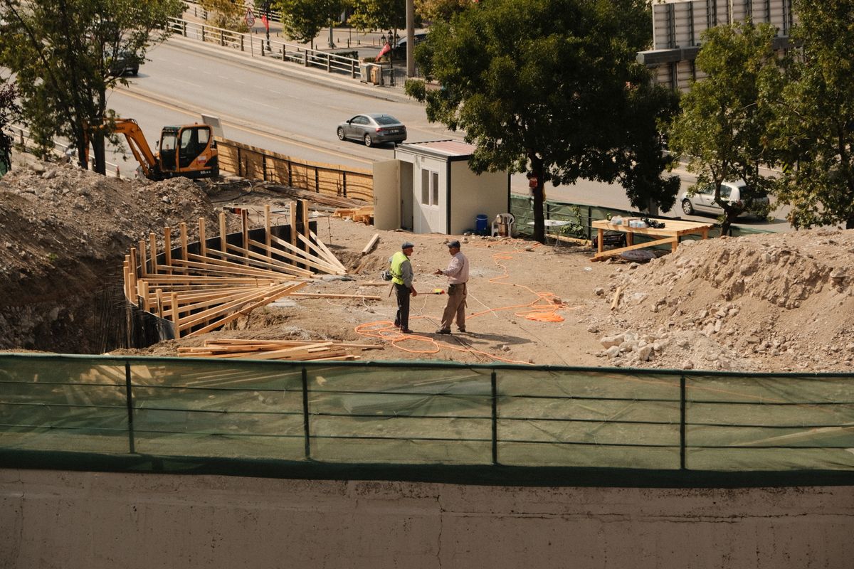 Maître d’œuvre échangeant avec un intervenant au centre d’un chantier